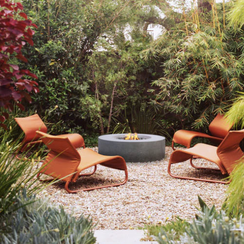 Creating an Oasis: The Importance of a Well-Designed Backyard with a Concrete Fire Pit, Pergola, and Furniture