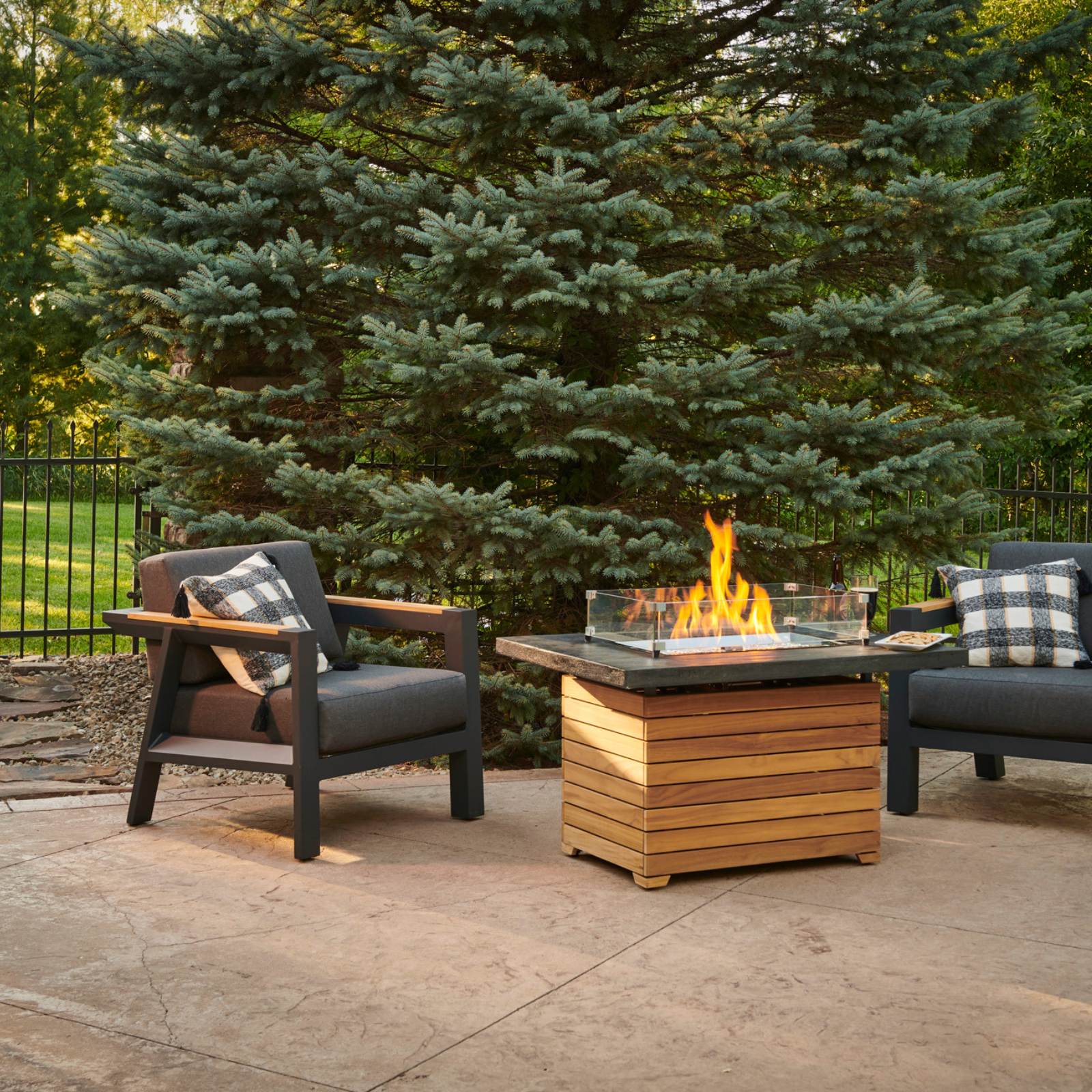 "Experience the durable sophistication of the Darien Gas Fire Pit Table. Crafted from Grade-A teak wood with an Everblend™ concrete top. Compatible with propane and natural gas, it provides warmth and ambiance for your outdoor space."