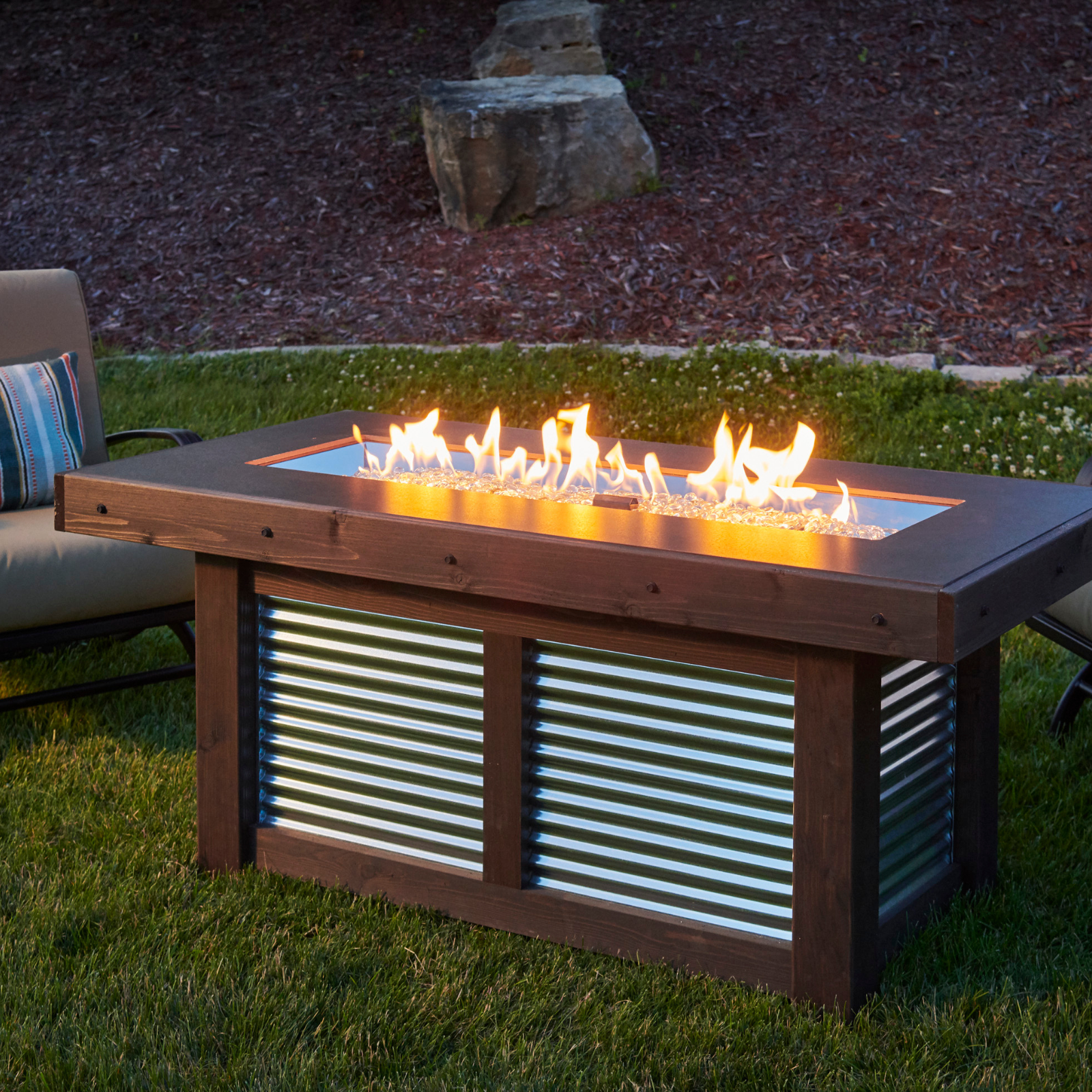 "Create cherished memories with the Denali Brew Gas Fire Pit Table. Propane and natural gas compatible. Everblend™ concrete top, corrugated metal base, and mocha-stained wood enclosure for a stunning aesthetic. Built-in bottle opener for convenience during outdoor gatherings."