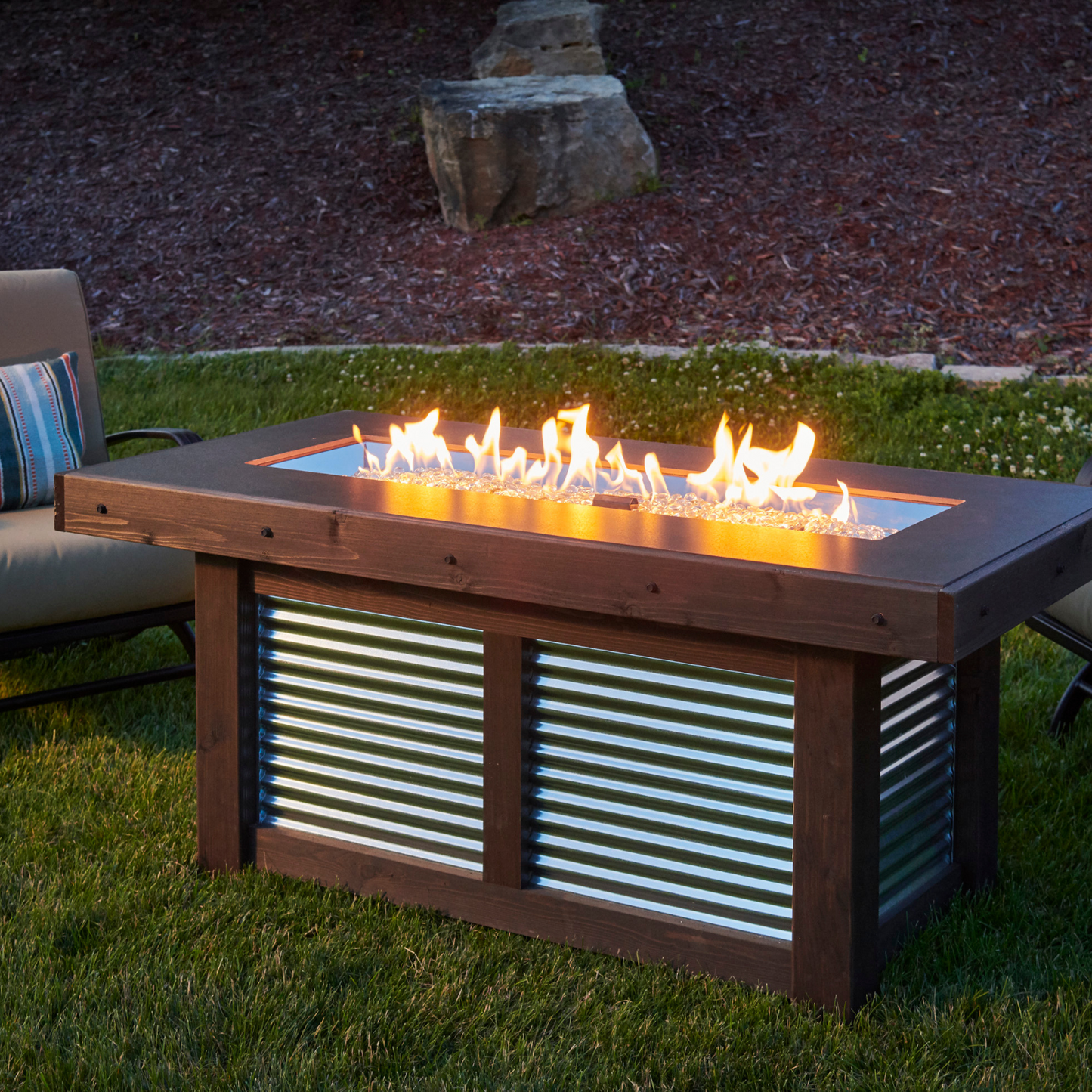 "Create cherished memories with the Denali Brew Gas Fire Pit Table. Propane and natural gas compatible. Everblend™ concrete top, corrugated metal base, and mocha-stained wood enclosure for a stunning aesthetic. Built-in bottle opener for convenience during outdoor gatherings."